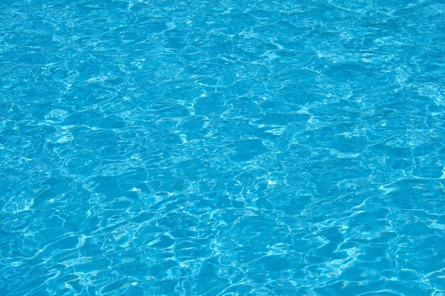 Nahaufnahmeoberfläche des blauen klaren Wassers mit kleinen Kräuselungswellen im Swimmingpool