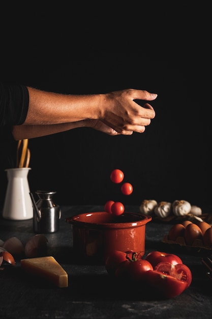 Nahaufnahmeperson, die Tomaten in eine Schüssel einsetzt