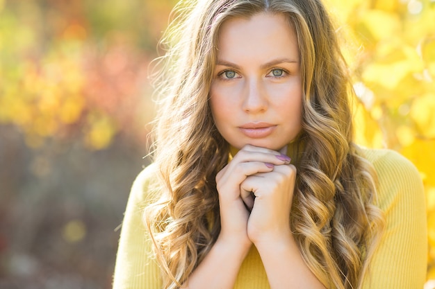 Nahaufnahmeporträt der jungen schönen Frau am Herbst. Stilvolle attraktive Frau in der Herbstzeit. Blonde Frau mit lockigem Haar.