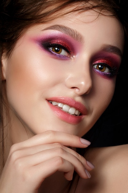 Nahaufnahmeporträt der jungen schönen Frau mit hellen rosa rauchigen Augen und Lippen