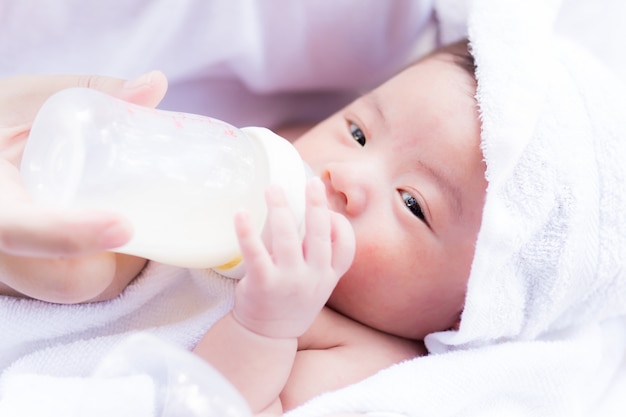 Nahaufnahmeporträt der Mutter neugeborenes Baby durch Milchflasche einziehend