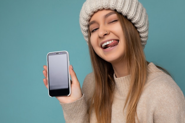 Nahaufnahmeporträt der schönen sexy positiven gutaussehenden jungen frau, die lokalisiert über blau balanciert