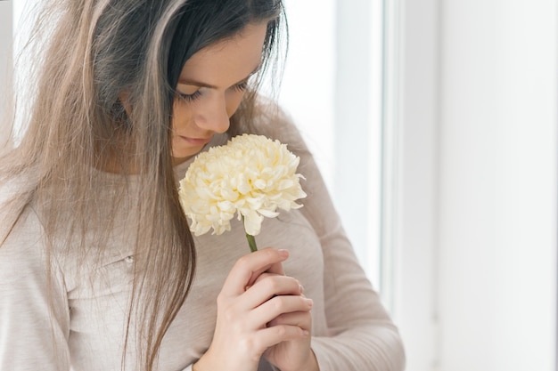 Nahaufnahmeporträt des Mädchens mit großer hellgelber Blume