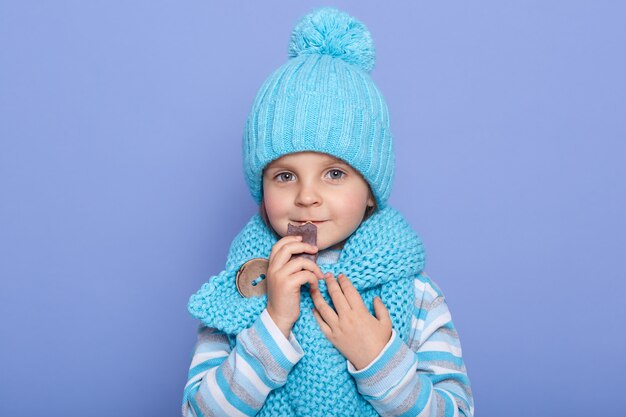 Nahaufnahmeporträt des süßen niedlichen blauäugigen kleinen Mädchens, das blauen Schal trägt