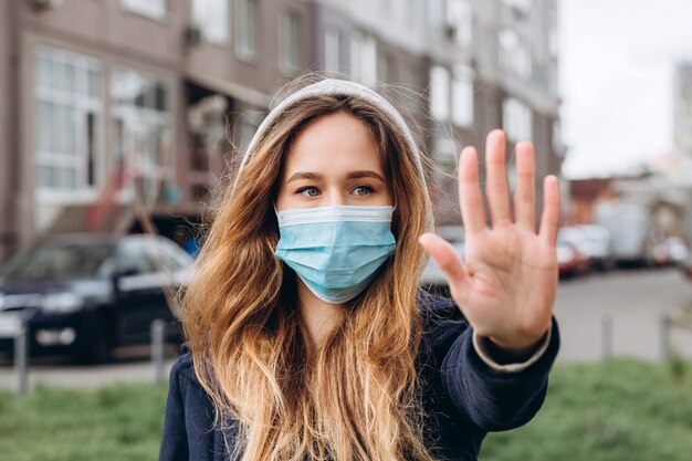 Nahaufnahmeporträt einer Frau in einer medizinischen Maske auf der Straße, Epidemie eines Coronavirus. Frau verstieß gegen die Regeln der Selbstisolation. SARS-CoV-2. Schützen Sie sich vor COVID-19.