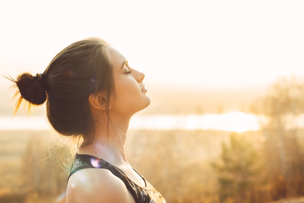 Nahaufnahmeporträt einer hübschen jungen Frau in der Sonne. Joggen am Morgen oder Sport im Freien