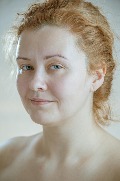 Foto nahaufnahmeporträt einer jungen erwachsenen attraktiven frau mit dem roten haar ohne make-up. kunst tonisieren. weicher fokus. neutraler hintergrund.