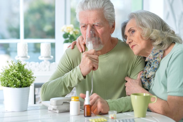 Nahaufnahmeporträt eines älteren Paares, das Inhalation macht