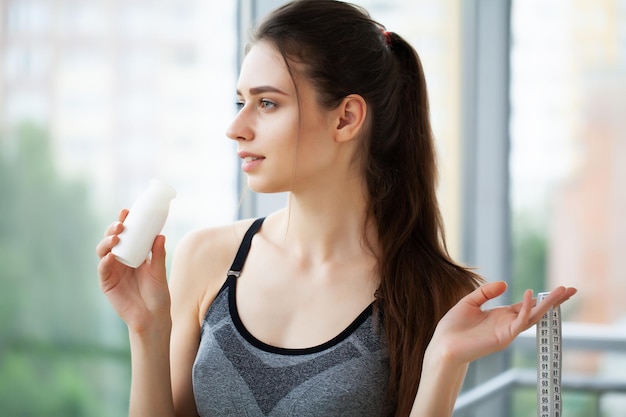 Nahaufnahmeporträt eines attraktiven Getränkjoghurts der jungen Frau