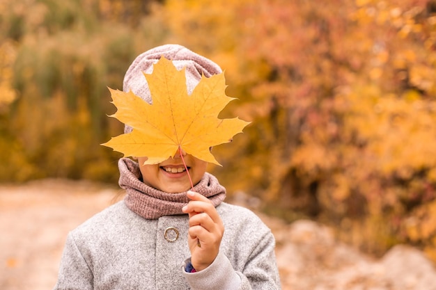 Nahaufnahmeporträt eines hübschen kleinen Mädchens, das sich im herbstlichen Park ausruht