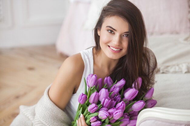 Nahaufnahmeporträt og junge sehr schöne brünette Frau mit Blumen