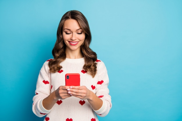 Nahaufnahmeporträt reizendes hübsches niedliches fröhliches Mädchen, das Gerät verwendet, das Urlaubsfreizeit verbringt, das Senden von SMS sendet
