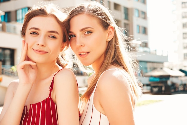 Nahaufnahmeporträt von zwei jungen, schönen, lächelnden Hipster-Frauen im trendigen weißen T-Shirt im Sommer