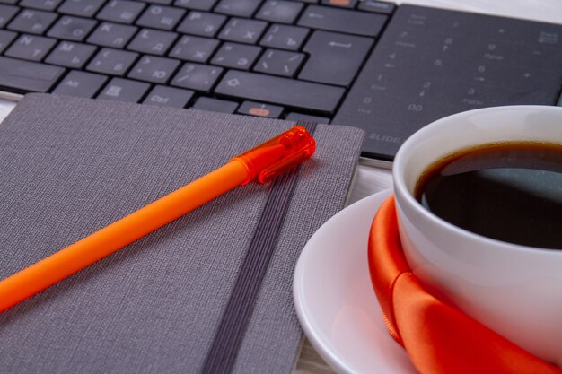 Nahaufnahmestift mit Tasse Kaffee und PC-Tastatur.