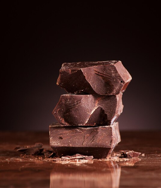 Nahaufnahmestücke Schokolade auf einem dunklen Marmorhintergrund