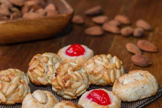 Nahaufnahmeteller mit katalanischen Panellets und einigen gerösteten Mandeln auf einem Holztisch