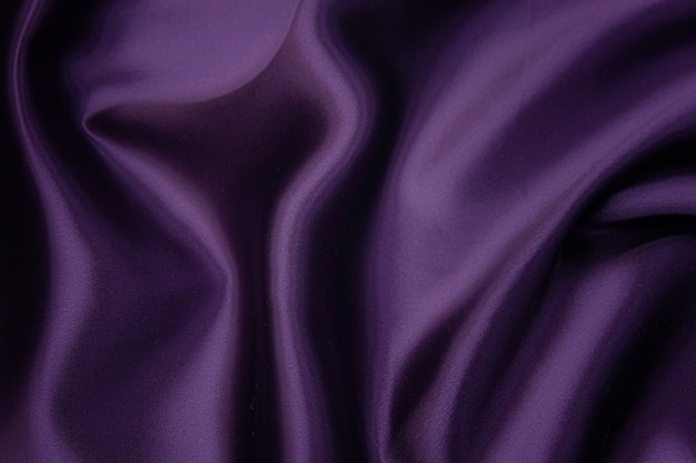 Nahaufnahmetextur von natürlichem violettem Stoff oder Stoff in der gleichen Farbe. Gewebestruktur aus natürlicher Baumwolle, Seide oder Wolle oder Leinentextilmaterial. Roter und orangefarbener Leinwandhintergrund.