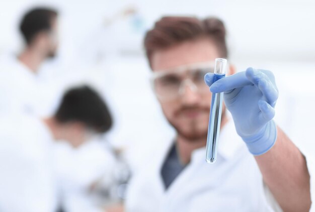 Nahaufnahmewissenschaftler mit Becher auf Laborhintergrund