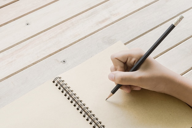 Naher Schuss einer menschlichen Handschrift etwas auf dem Papier, selektiver Fokus an Hand