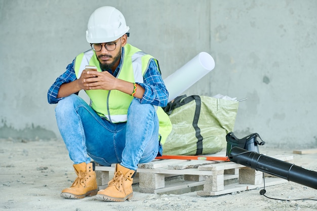 Nahöstlicher Arbeiter mit Smartphone