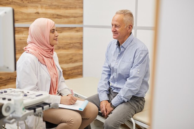 Nahöstlicher Arzt im Gespräch mit einem älteren Patienten