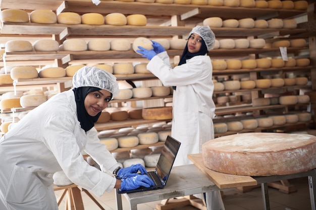 nahöstliches schwarzafrikanisches muslimisches weibliches geschäftsfrauenteam in einem lokalen lebensmittelproduktionsunternehmen für kuh- und ziegenmilchkäse