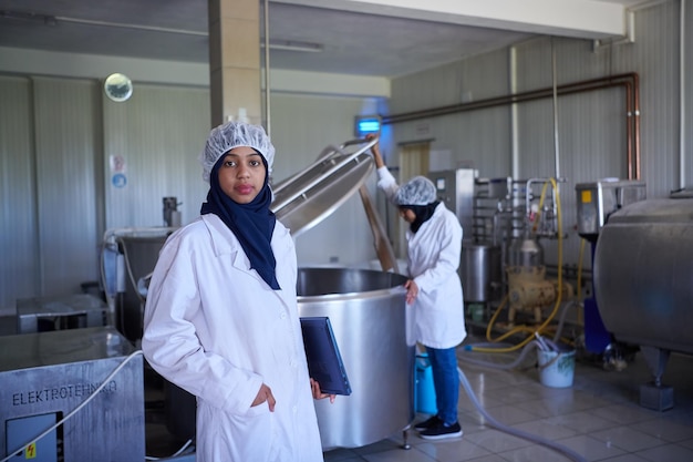 nahöstliches schwarzafrikanisches muslimisches weibliches geschäftsfrauenteam in einem lokalen lebensmittelproduktionsunternehmen für kuh- und ziegenmilchkäse