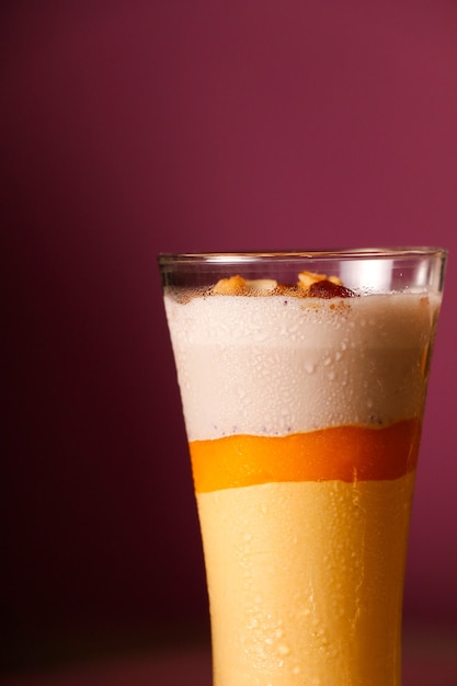 Nahrhafter Mango-Milchshake auf rosa Hintergrund