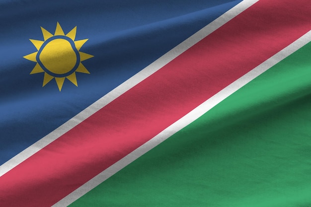 Namibia-Flagge mit großen Falten, die in der Nähe unter dem Studiolicht im Innenbereich winken Die offiziellen Symbole und Farben im Banner
