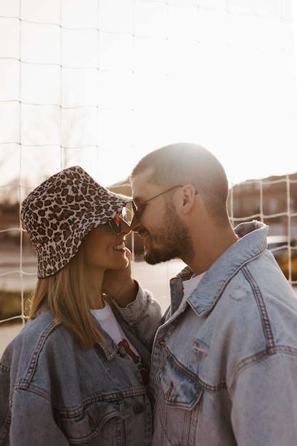 Namorada e namorado na cerca olhando um para o outro e tocando os narizes casal feliz