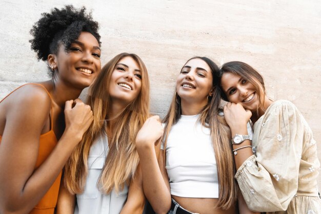 Foto namoradas alegres se divertindo em pé contra uma parede - um grupo de jovens alegres se reúne despreocupadas