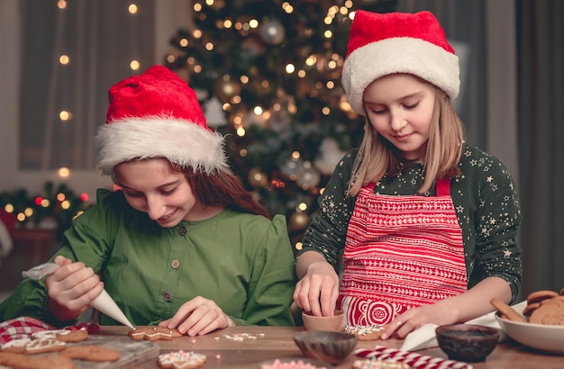 Namoradas felizes mostrando pão de mel decorado em casa