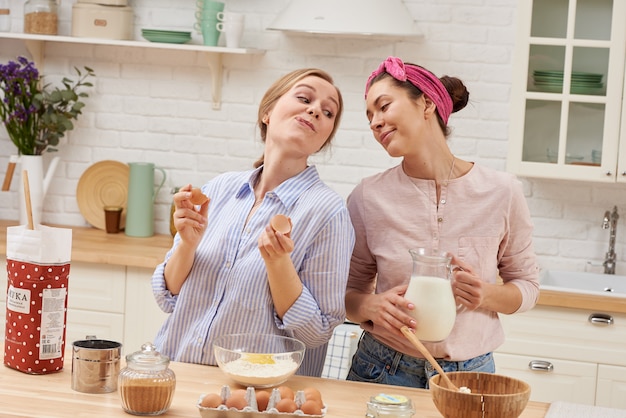 Namoradas felizes preparam café da manhã na cozinha