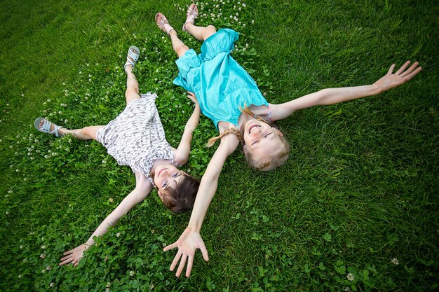 Namoradas meninas sorridentes na grama verde. feriados infantis