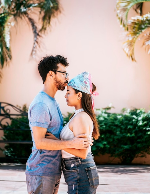 Namorado beijando ternamente a testa da namorada Homem beijando a testa da namorada lá fora Casal fofo abraçando o namorado beija a testa da menina Retrato de lindo casal apaixonado