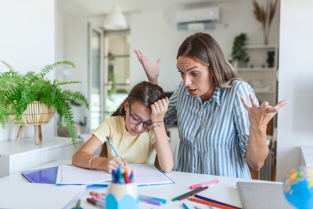 Não me ignore quando estou falando. mães ajudando com a lição de casa. a mãe está zangada porque a filha não quer fazer o dever de casa. mãe estressada e filha frustradas por causa do fracasso no dever de casa.