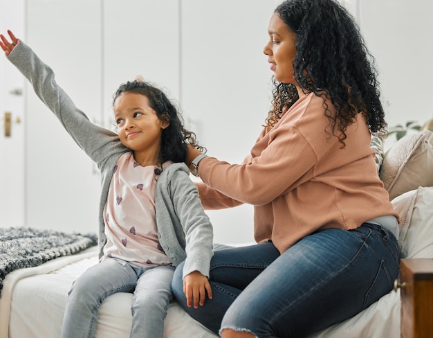 Não posso esquecer de escovar o cabelo Foto de uma jovem mãe escovando o cabelo da filha em casa