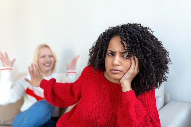 Não quero ouvir mulher cansada perturbada infeliz se comunicando com a amiga sentada perto dela no sofá apertando as mãos amigos discutindo no sofá em casa duas amigas discutindo