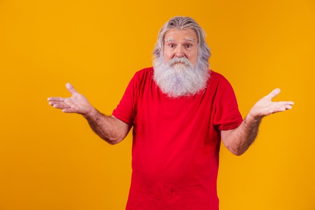 Não sei. homem idoso caucasiano confuso sobre fundo amarelo, gesticulando os braços e a expressão facial.