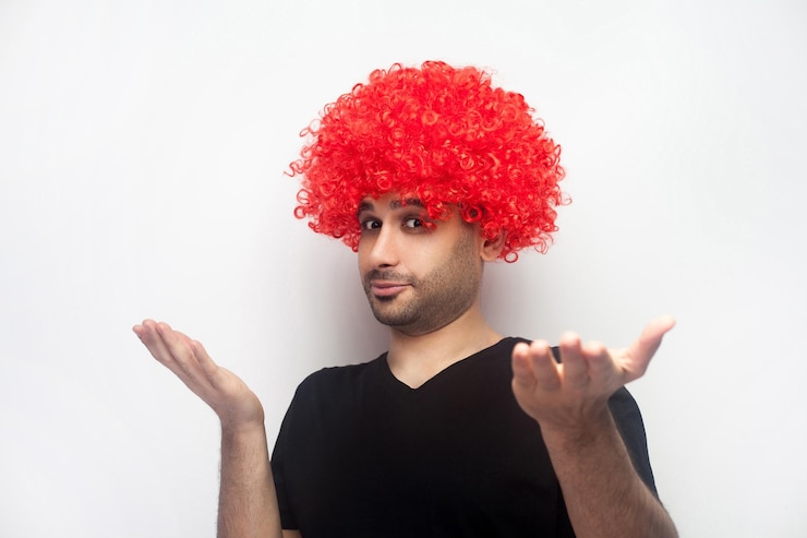 Foto não sei quem se importa retrato de homem bizarro engraçado com peruca vermelha encaracolada e cerdas levantando as mãos em perplexidade olhando com expressão confusa indignada studio shot isolado no fundo branco