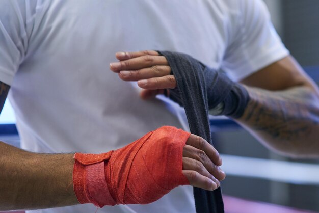 Não subestime a importância do envoltório de mão Foto de um homem irreconhecível amarrando suas mãos e pulsos na academia de boxe