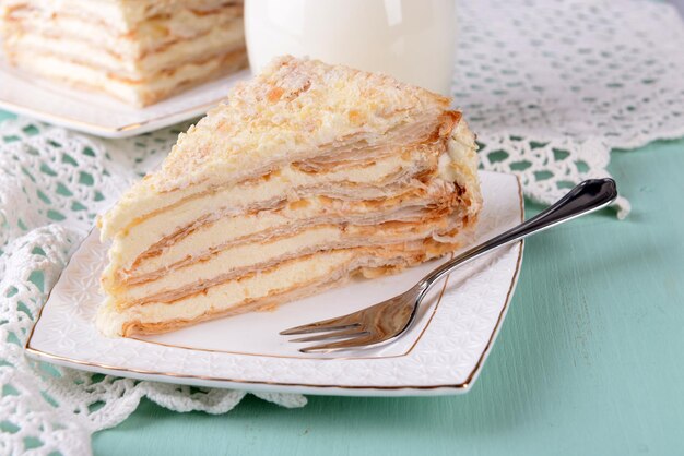 Napoleon-Kuchen auf dem Teller auf dem Tisch in der Nähe