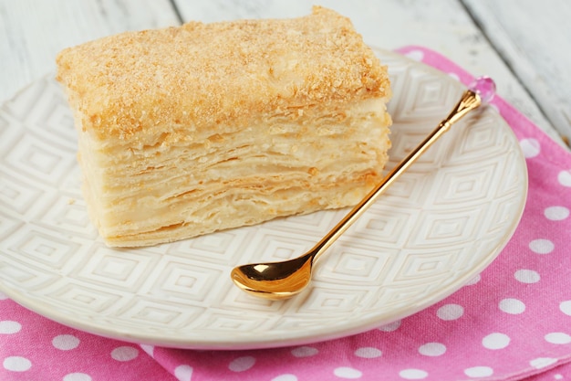 Napoleon-Kuchen auf dem Teller auf dem Tisch in der Nähe