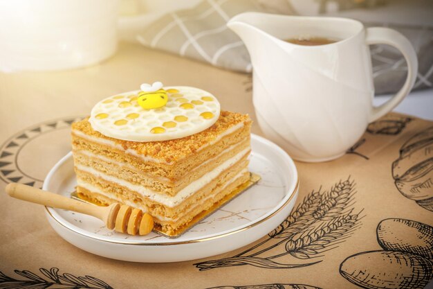 Napoleon-Kuchen mit einer Tasse Honig auf einem Tischtuch in Nahaufnahme