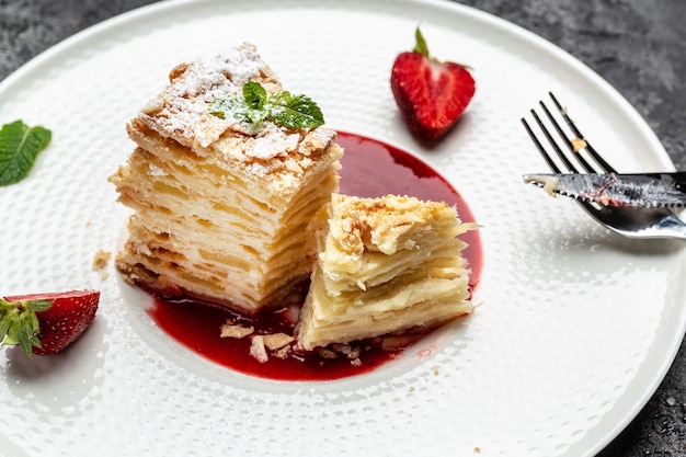 Napoleon-Kuchen. Wunderschöner Kuchen mit mit cremiger Vanillesoße, Äpfeln und Erdbeermarmelade dekorierter Minze