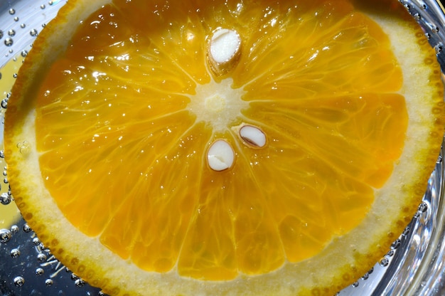 Naranja en agua con gas con burbujas. macro.