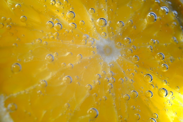 Naranja en agua con gas con burbujas. macro.