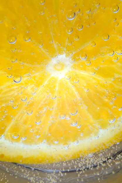 Naranja en agua con gas con burbujas. macro.