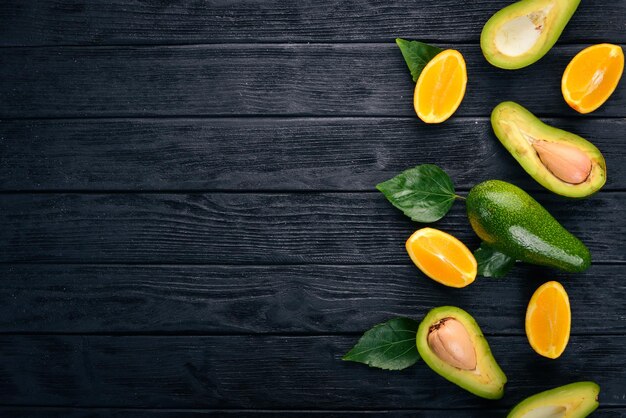 Naranja y aguacate sobre un fondo de madera Vista superior Espacio libre para su texto