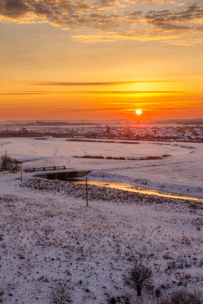 Naranja amanecer de invierno sobre el campo